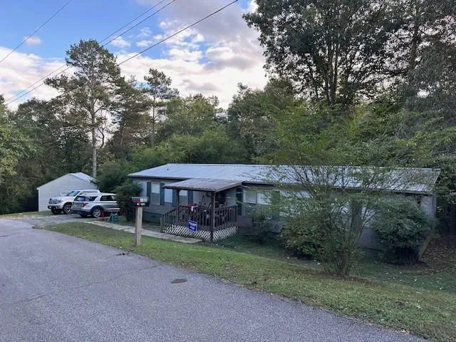 Single-story residential structure featuring a gray exterior siding and a covered front porch