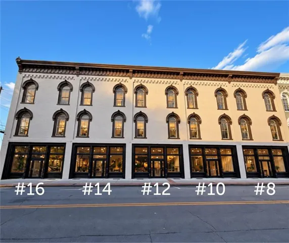 Multi-story facade featuring arched windows, decorative cornices, and a prominent storefront level