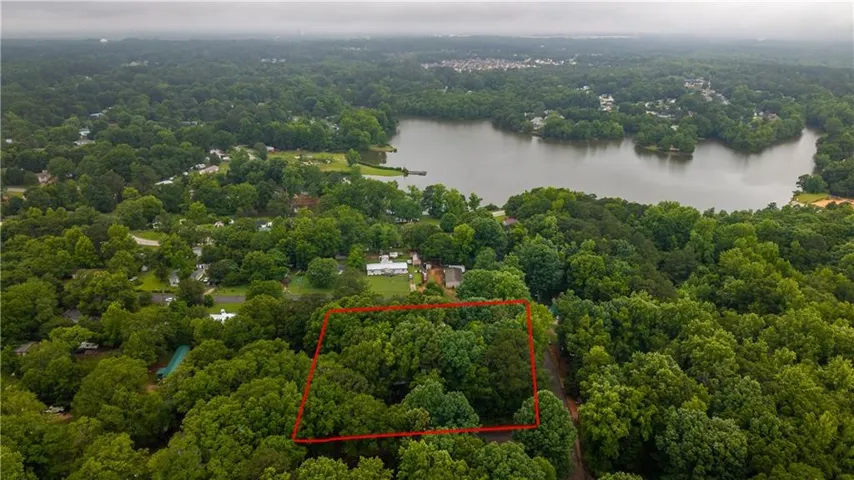Expansive treed lot featuring mature foliage and proximity to a large body of water