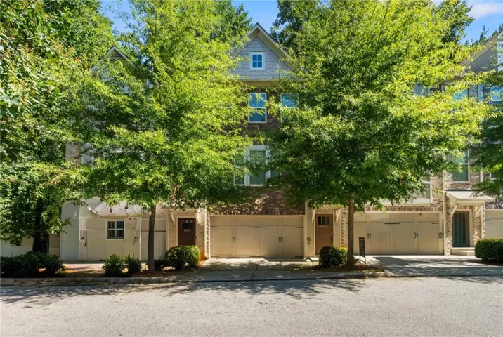 Stone and brick facade with multiple windows, featuring two distinct entry doors and garage access