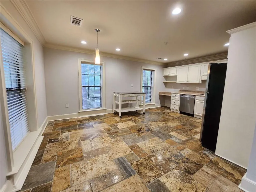 Kitchen with stainless steel appliances, white cabinetry, crown molding, light countertops, and recessed lighting