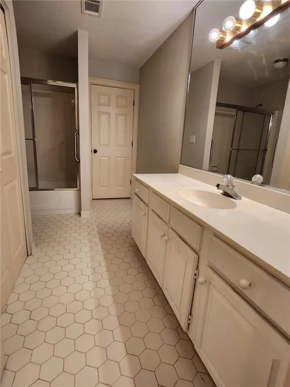 Bathroom with vanity and shower / bath combination with glass door