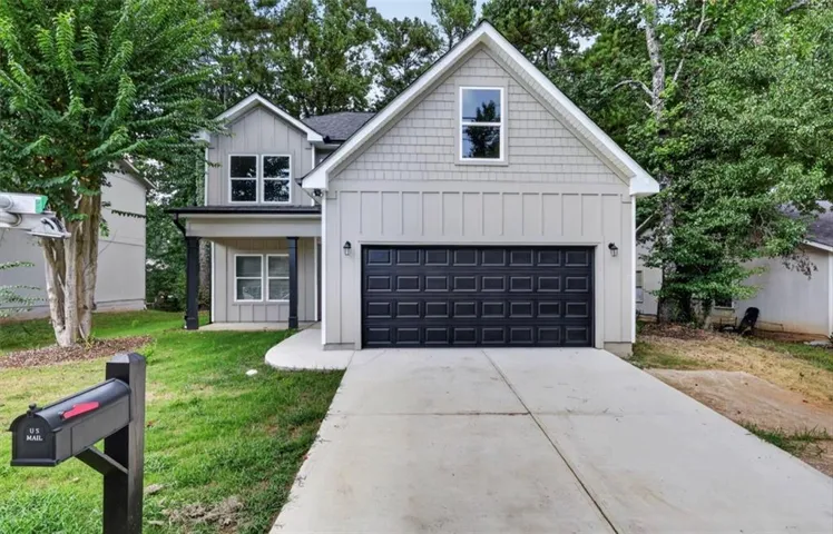 Two-story exterior with board and batten siding, shake shingle gables, and a two-car garage