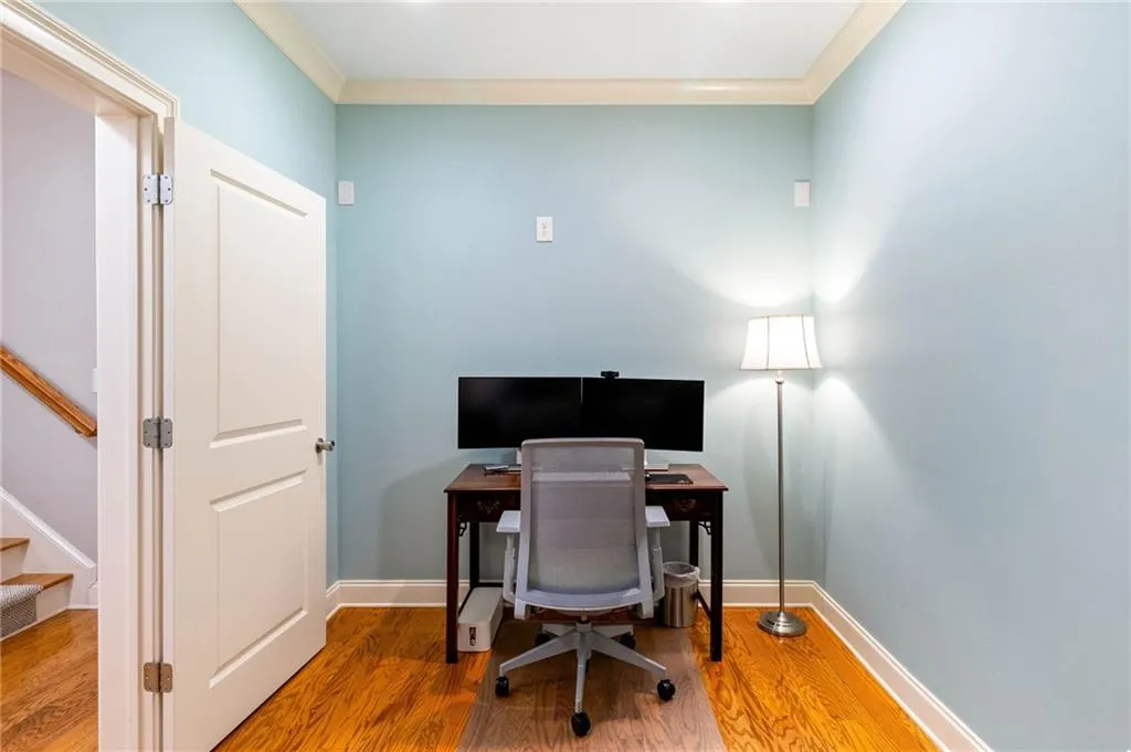 Home office with hardwood / wood-style flooring and ornamental molding