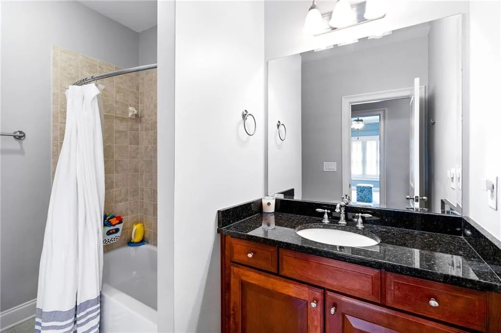 Bathroom featuring vanity and shower / tub combo with curtain