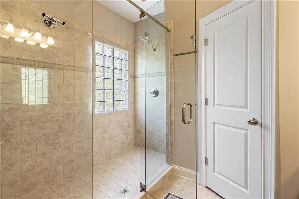 Bathroom featuring walk in shower and tile patterned flooring