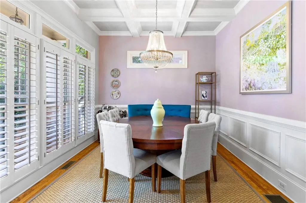 Dining room with coffered ceiling, an inviting chandelier, beamed ceiling, and light hardwood / wood-style floors
