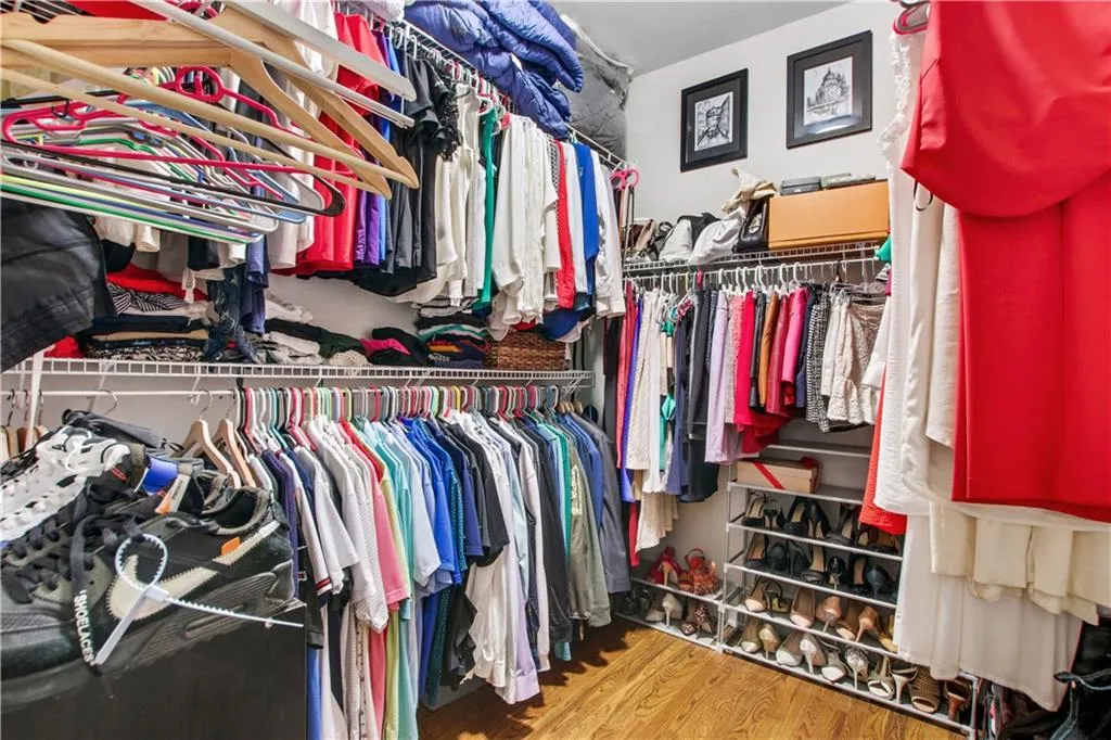 Walk in closet with wood-type flooring