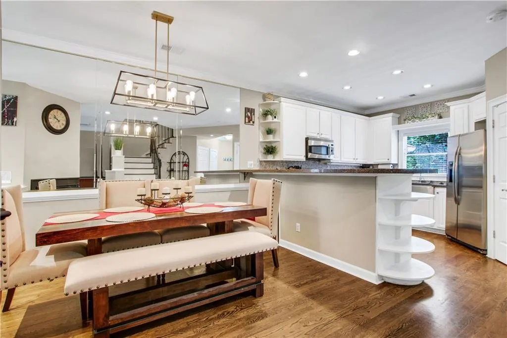 Dining space with an inviting chandelier, wood-type flooring, and crown molding