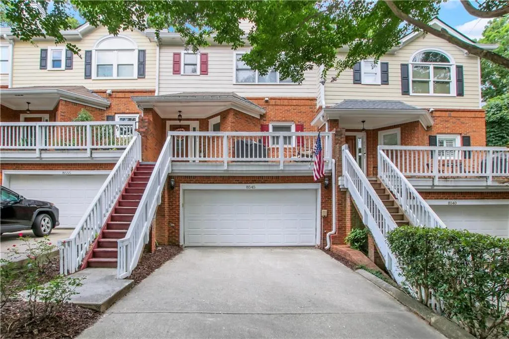 Townhome / multi-family property featuring a garage and covered porch