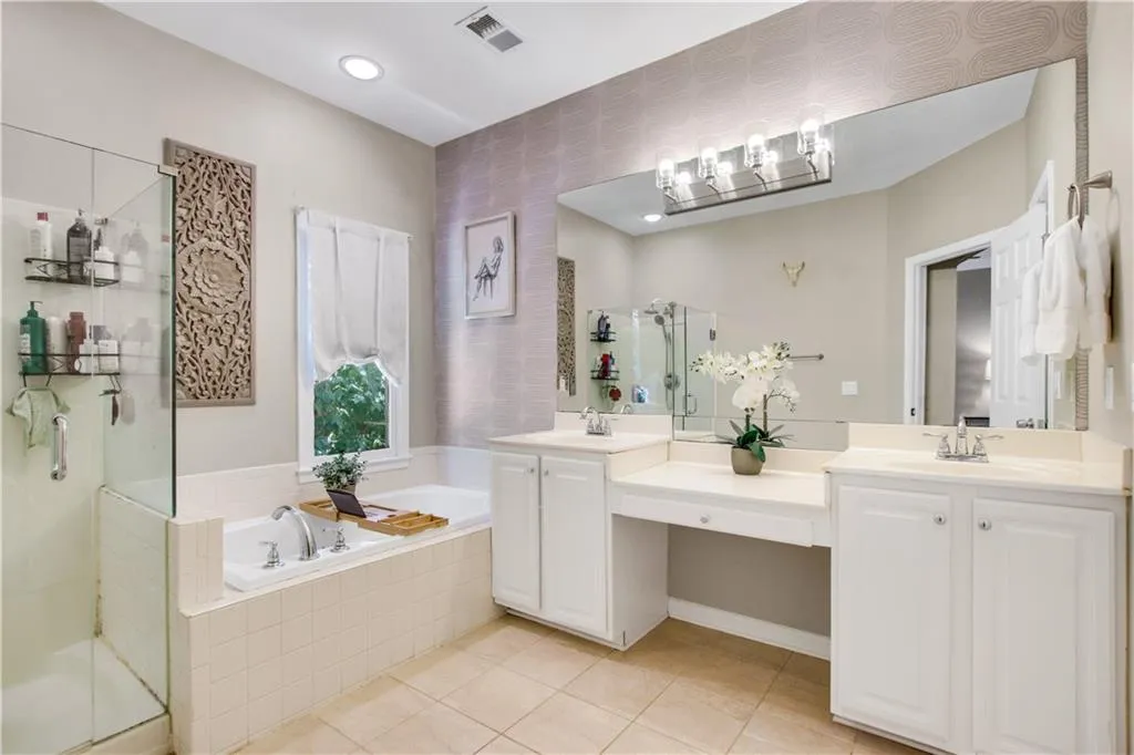 Bathroom with tile patterned flooring, independent shower and bath, and double vanity