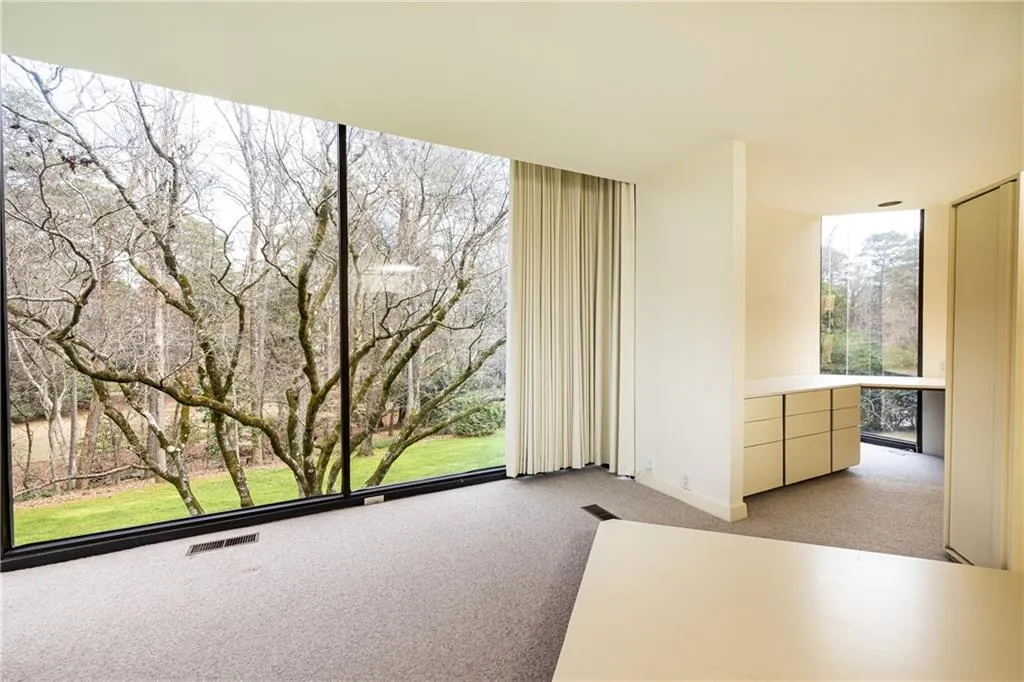 Primary Bedroom on second half level.  Full height classs view to front yard from primary bed
