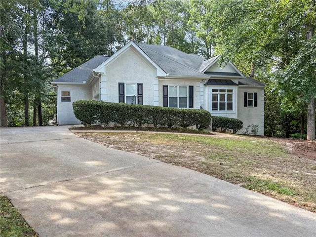 Classic white colonial home with a welcoming front elevation featuring black shutters, a peaked roofline, and a two-car attached garage