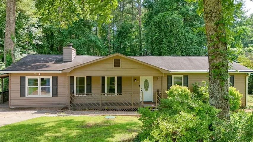 Ranch-style exterior with composite siding, covered front porch, and dark functional shutters