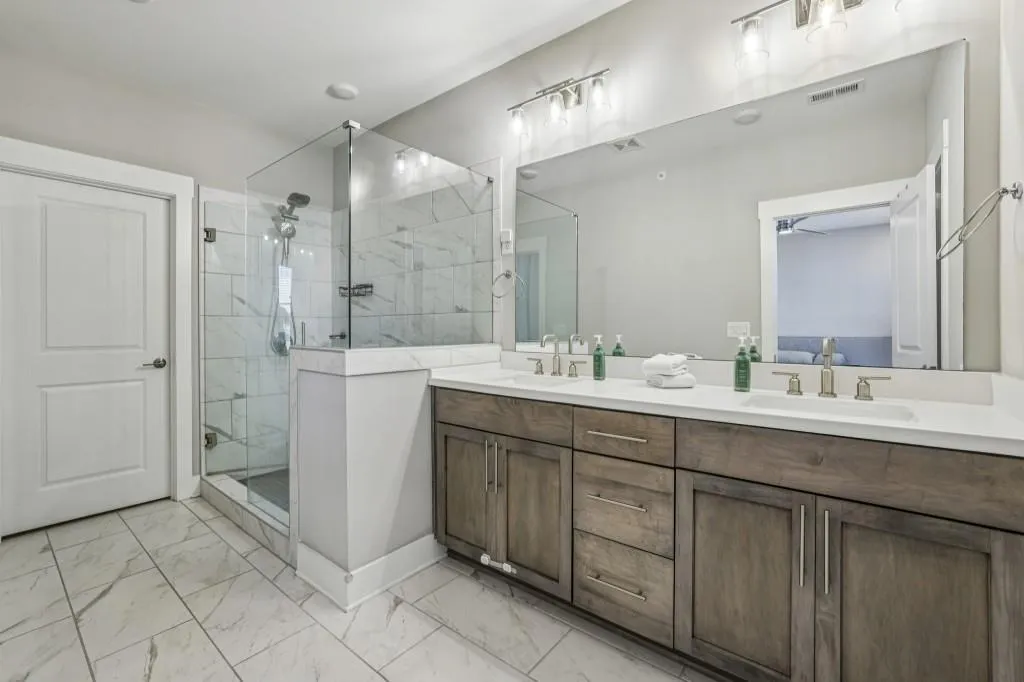 The Primary Suite is a luxurious retreat with a Double Stone Vanity, Glass-Enclosed Shower, and a Large Walk-In Closet