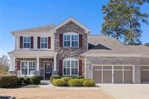 Two-story residence featuring a partial brick facade and a covered front porch