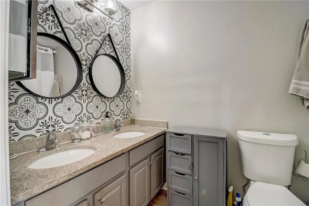 Full bath with double vanity and toilet