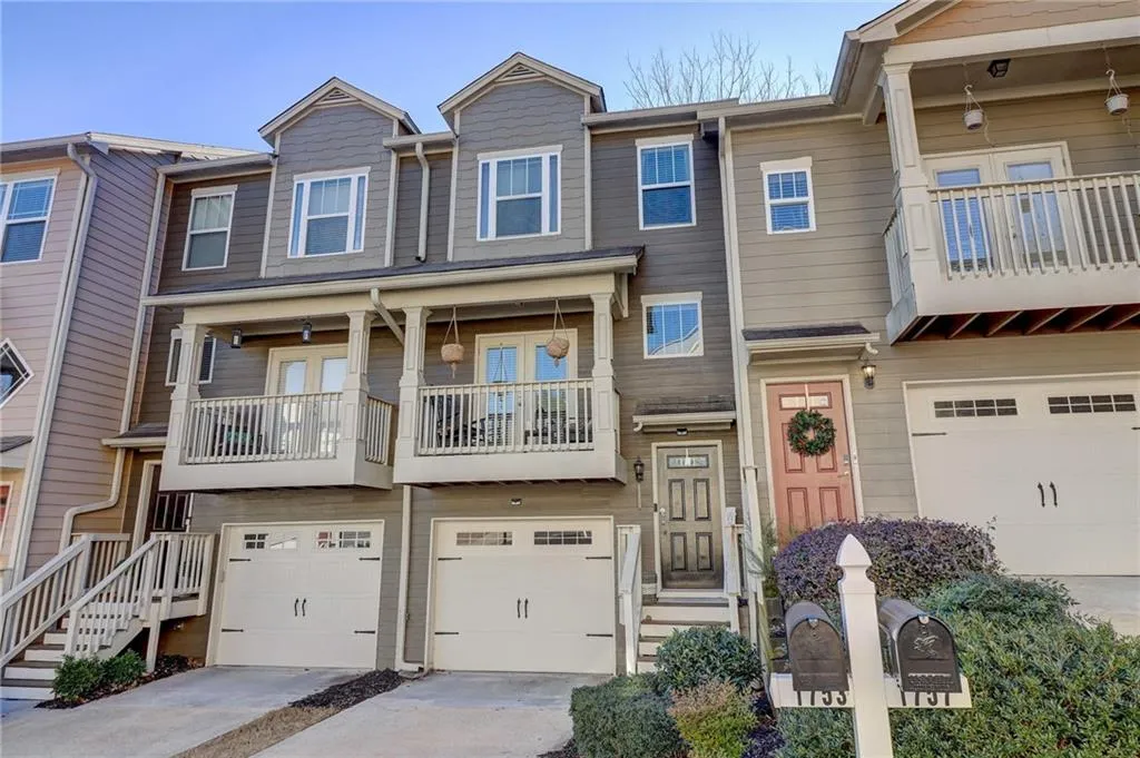 Craftsman-style house with an attached garage, a balcony, french doors, and concrete driveway