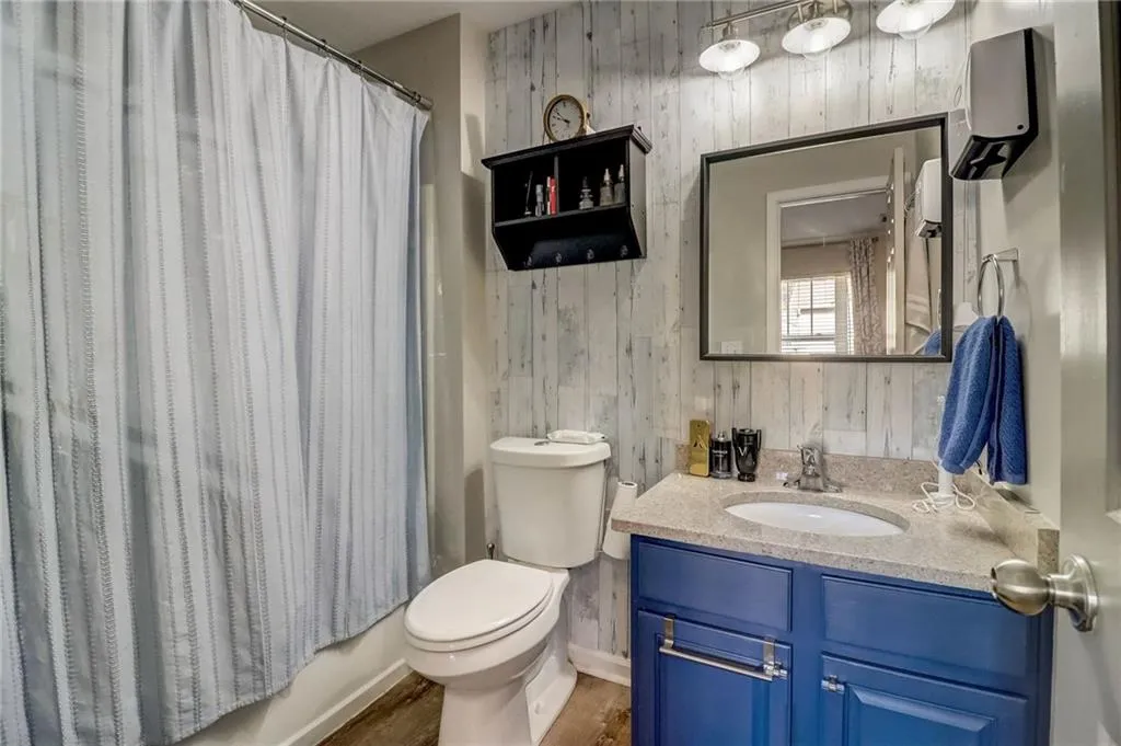 Bathroom featuring vanity, wooden walls, and shower / bath combo