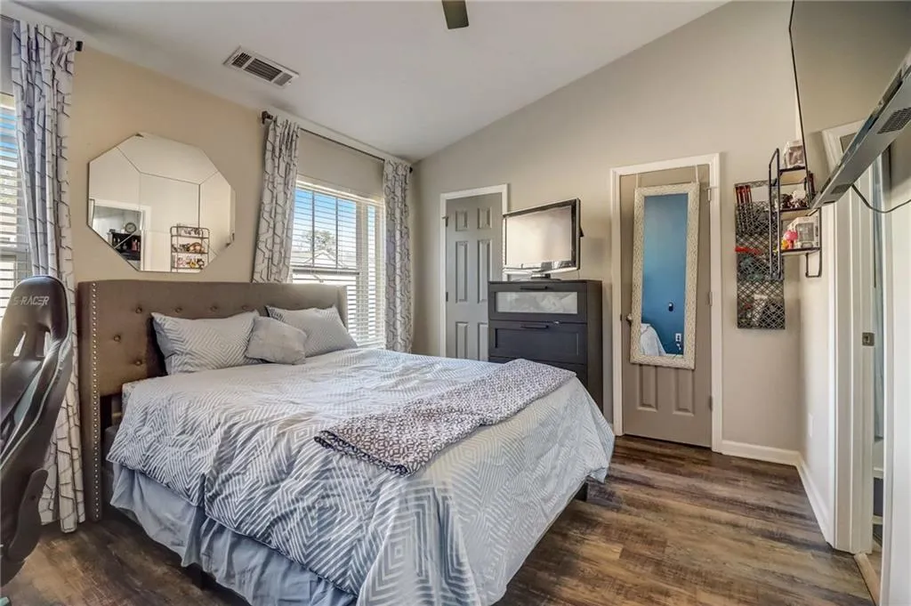 Bedroom featuring vaulted ceiling, dark wood-style floors, and a ceiling fan