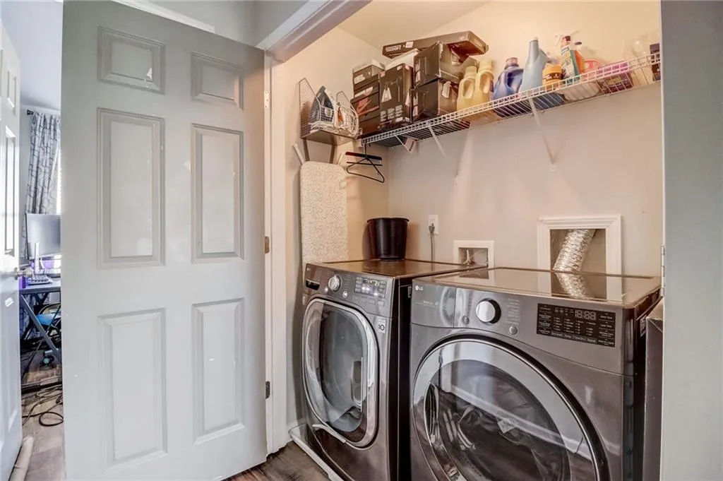 Laundry area with washing machine and clothes dryer and wood finished floors