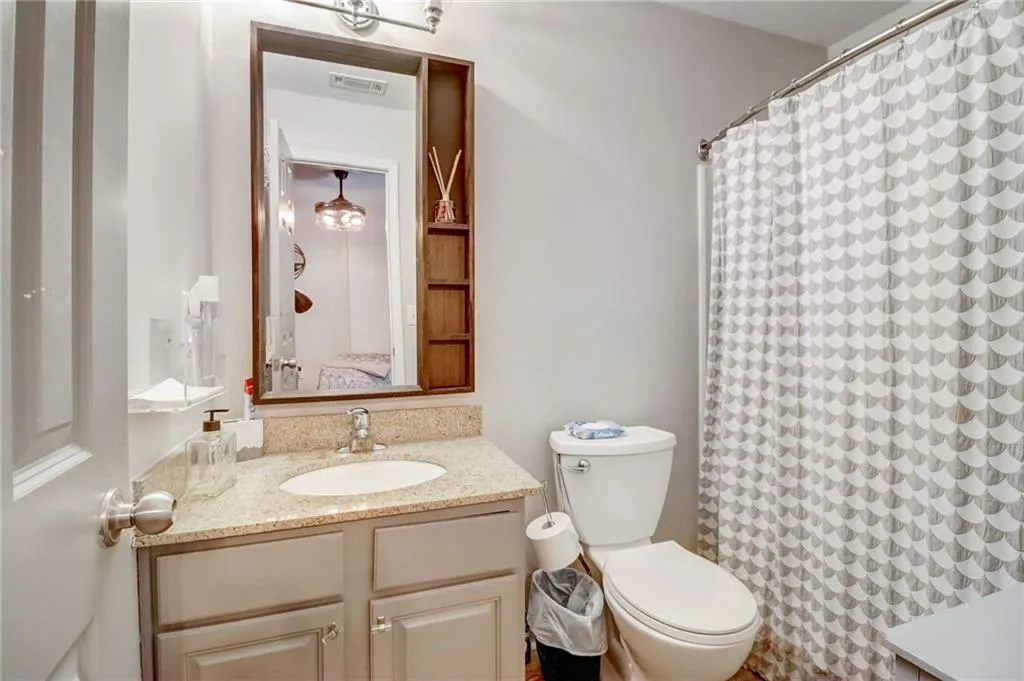 Ensuite bathroom with vanity and curtained shower