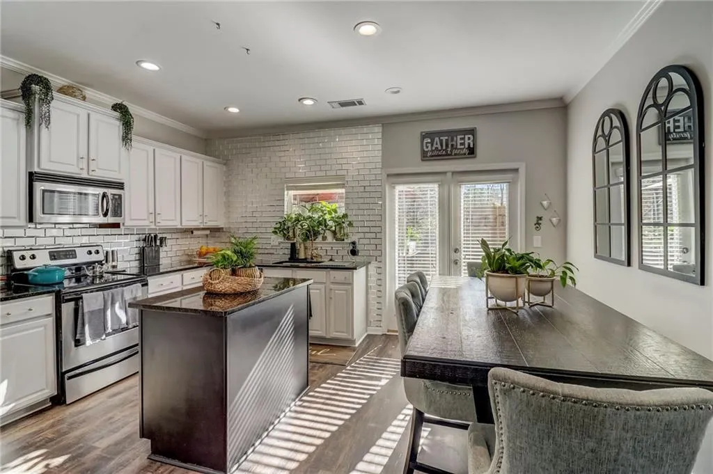 Kitchen featuring crown molding, stainless steel appliances, white cabinets, dark wood-style flooring, and recessed lighting