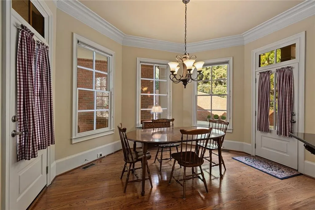 Dining room with crown molding, wood-type flooring, and a notable chandelier