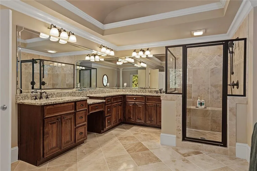 Bathroom featuring vanity, ornamental molding, and walk in shower