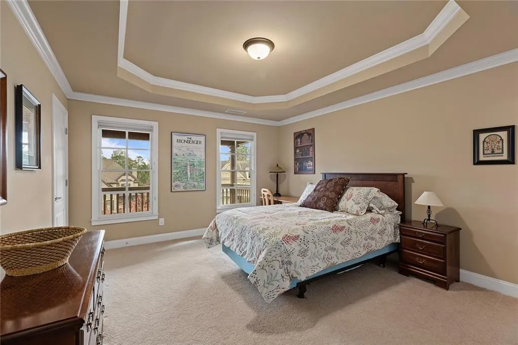Carpeted bedroom featuring ornamental molding and a tray ceiling