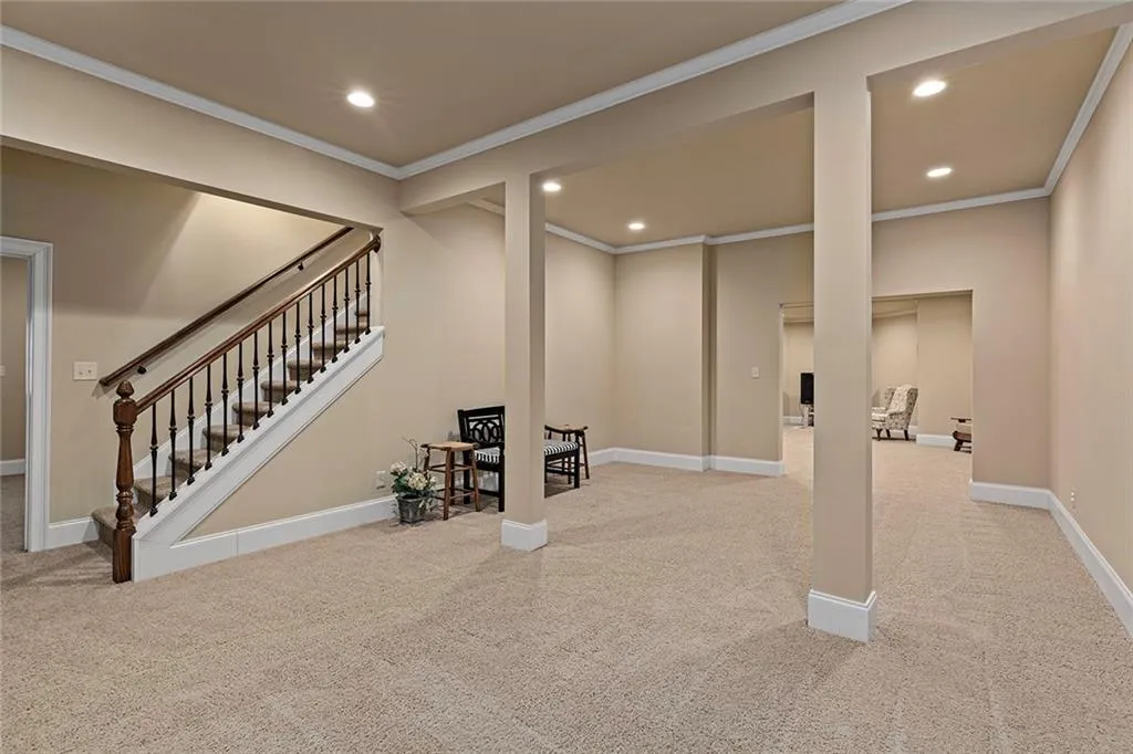 Basement featuring crown molding and light colored carpet