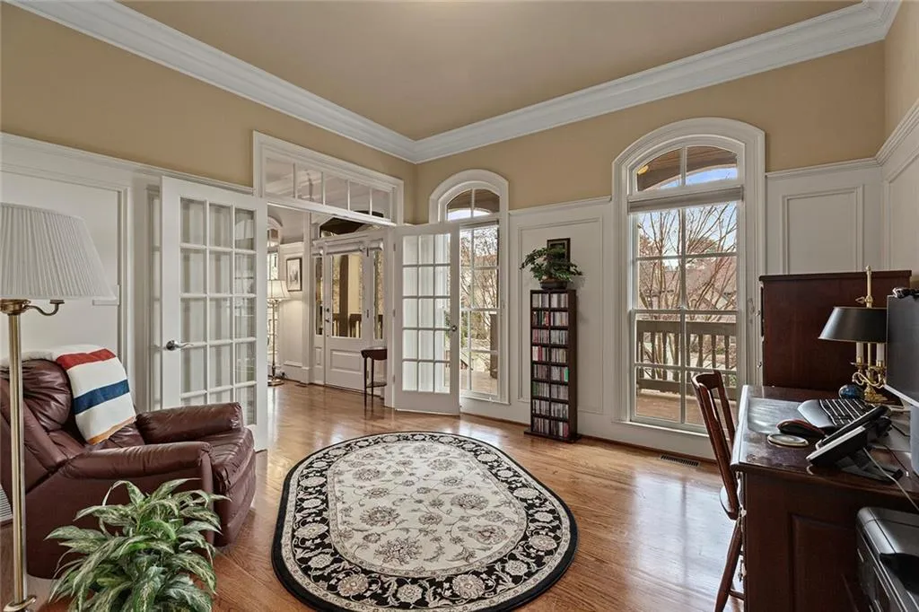Office area with crown molding, light wood-type flooring, and french doors