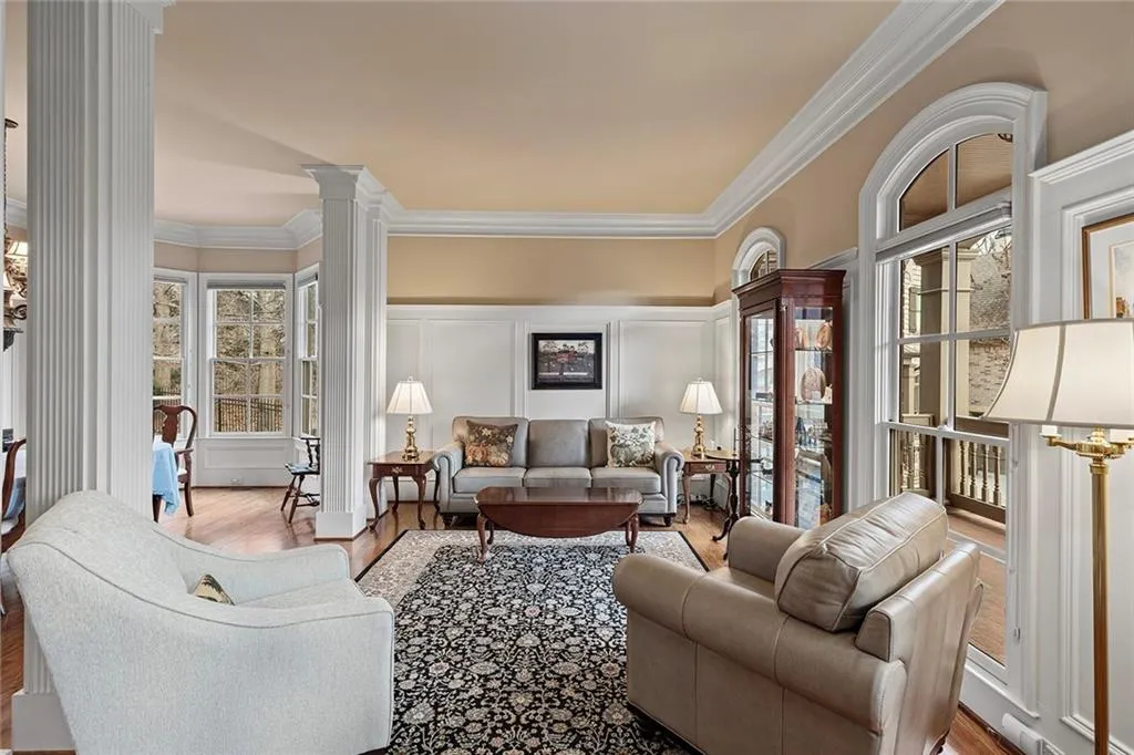 Living room with crown molding, light hardwood / wood-style flooring, and ornate columns