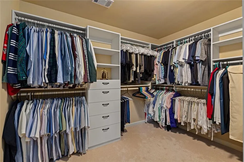 Walk in closet featuring light colored carpet