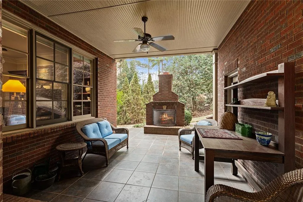 View of patio with exterior fireplace and ceiling fan