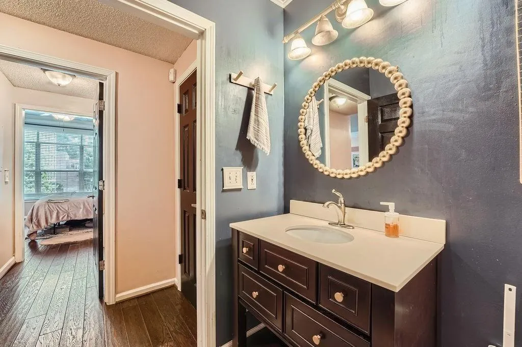 Bathroom featuring wood-type flooring, vanity, a textured ceiling, and connected bathroom