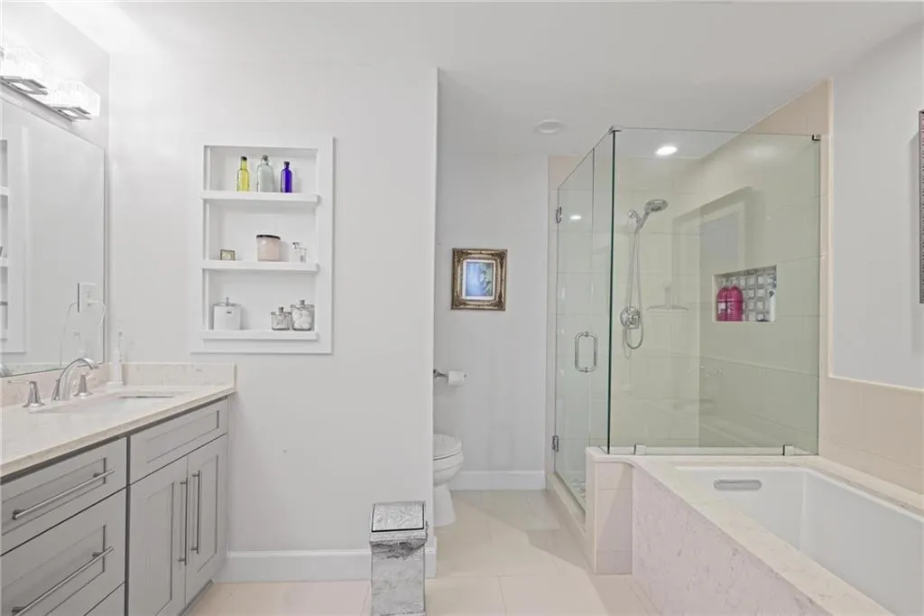 Primary Bathroom Suite with double vanity, a shower stall, and a garden tub