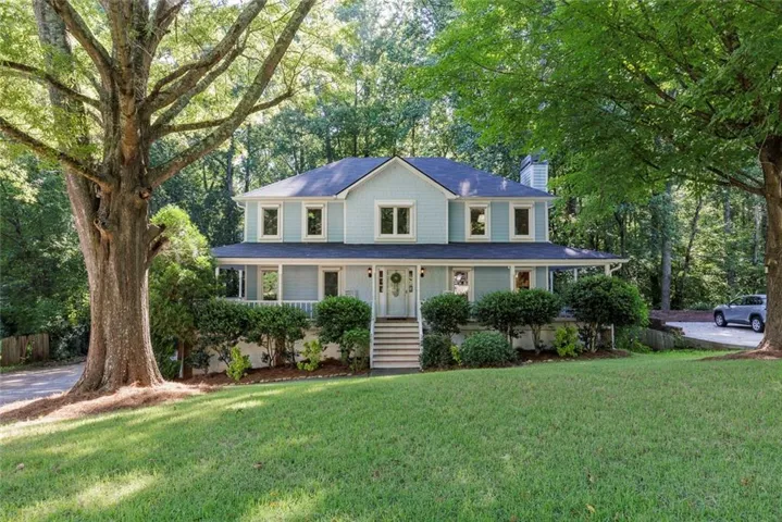 Two-story residence with a covered front porch, light blue siding, and white trim