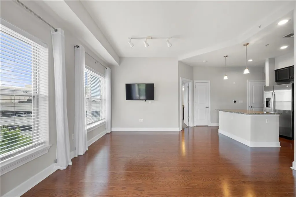 Unfurnished living room featuring dark wood-type flooring and recessed lighting