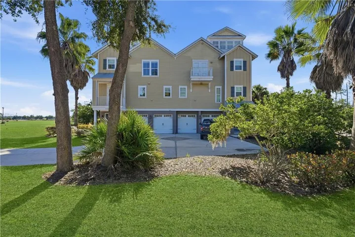 View of front of home featuring board and batten siding, a front lawn, an attached garage, and concrete driveway