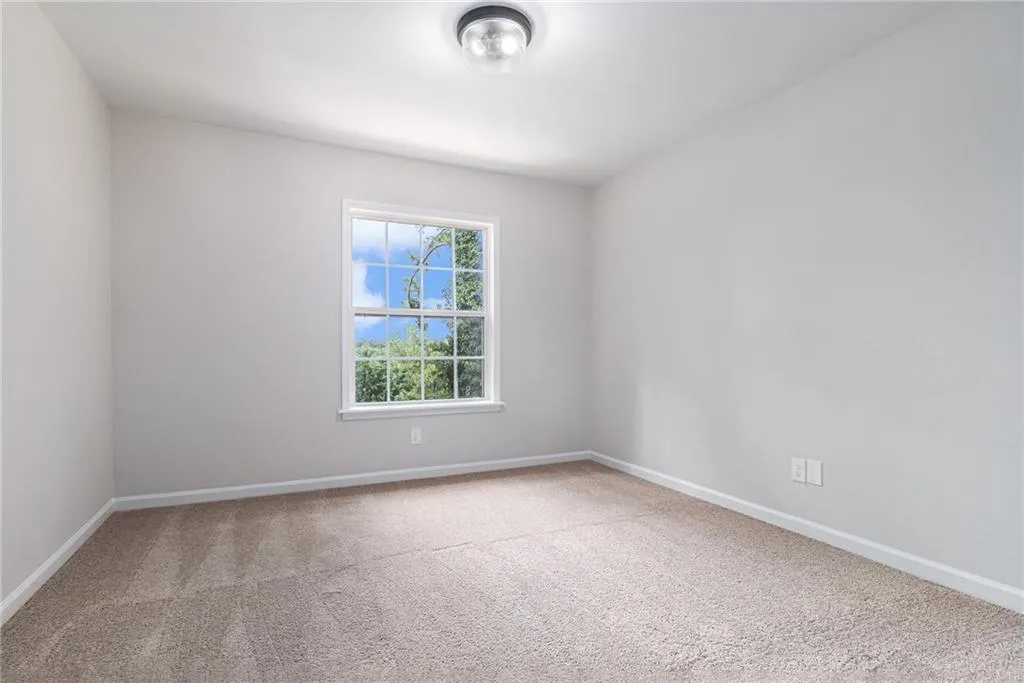 Unfurnished room featuring light colored carpet and baseboards