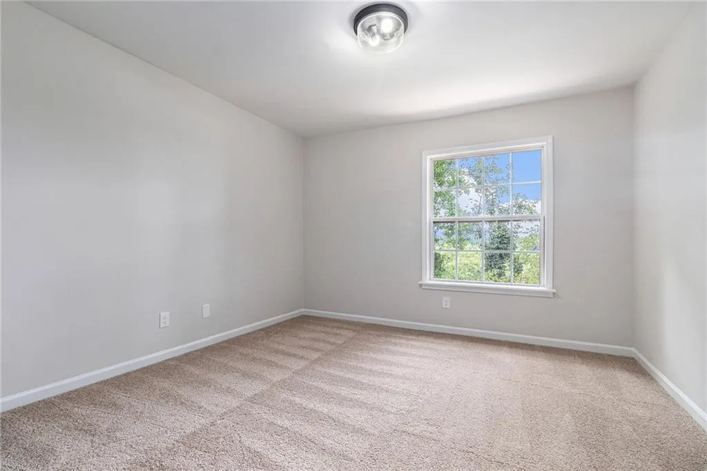 Spare room featuring baseboards and light carpet