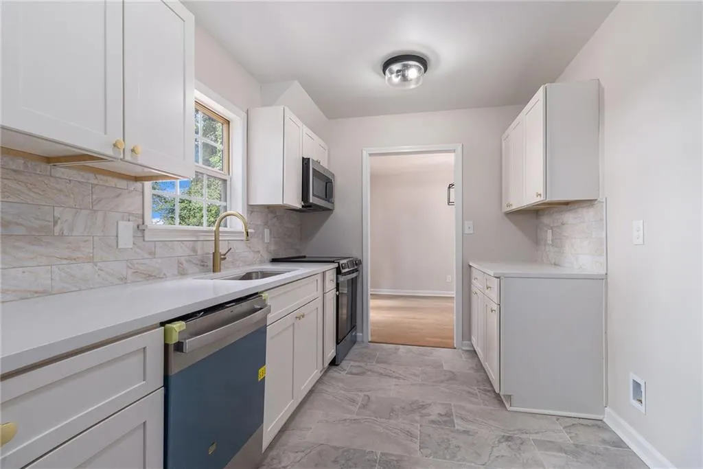 Kitchen featuring tasteful backsplash, range with electric cooktop, dishwasher, white cabinets, and stainless steel microwave
