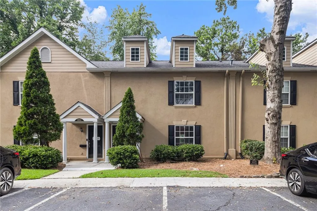 Traditional home with uncovered parking and stucco siding