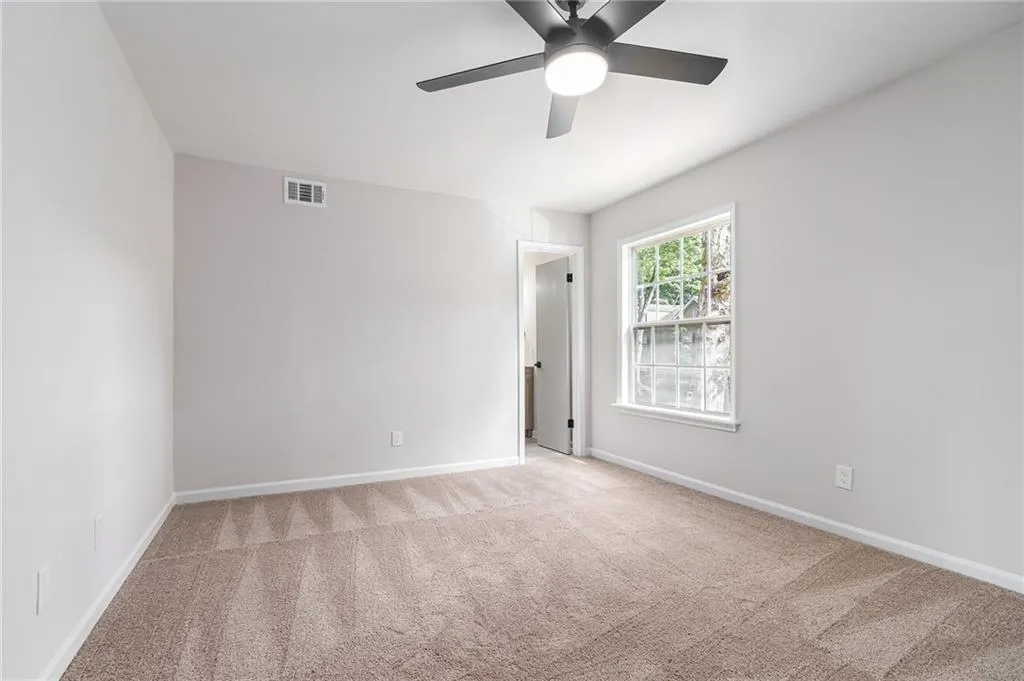 Spare room with light carpet and a ceiling fan