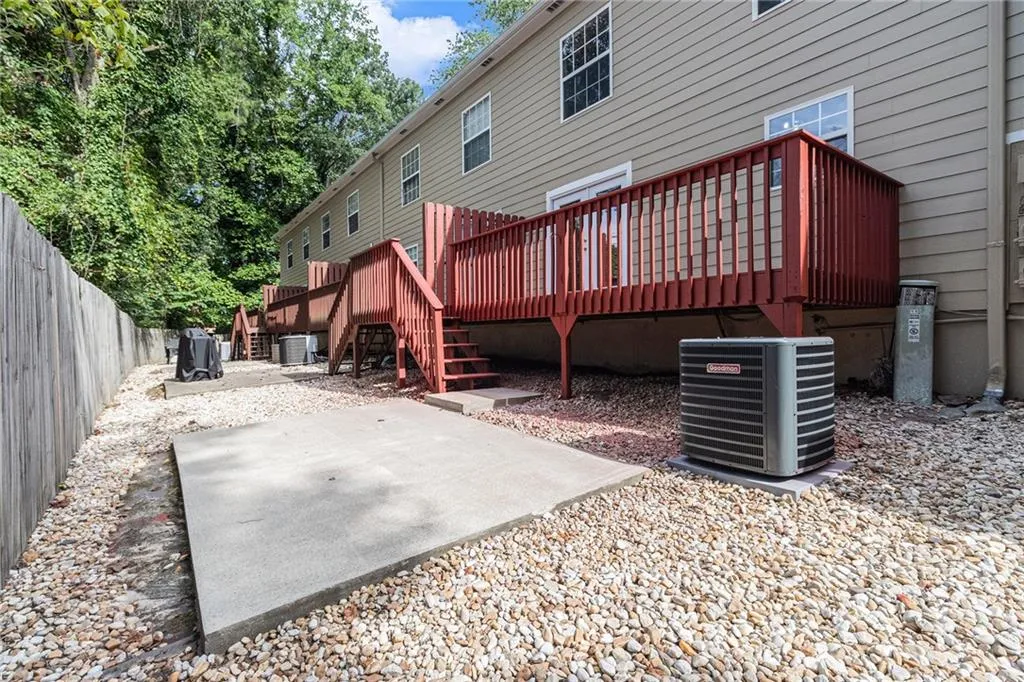 Rear view of house with a deck, stairway, a patio, and a fenced backyard