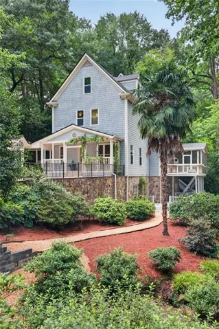 Shingle siding exterior with a gabled roof, stone foundation, covered front porch, and screened side porch