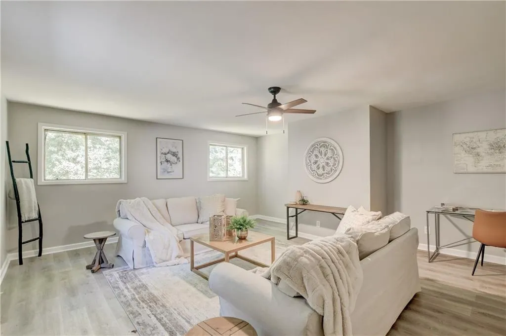 Living area featuring light wood-style floors and ceiling fan