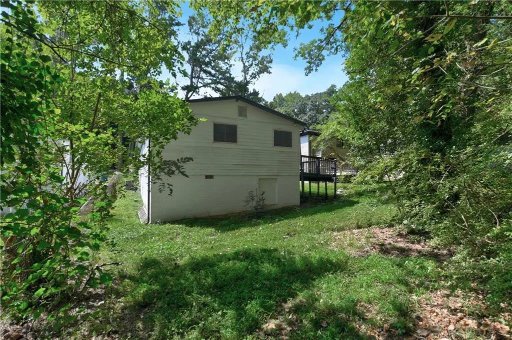 Rear view of house with a yard and a wooden deck