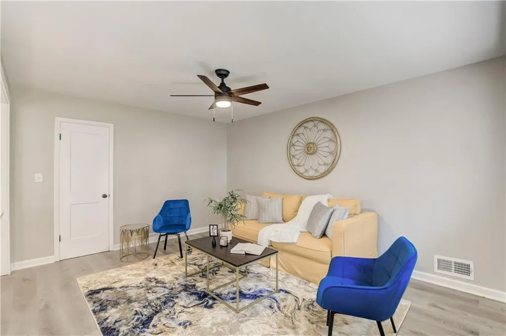 Living area with light wood finished floors and a ceiling fan